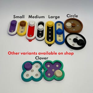 May include: An assortment of colourful fidget toys in various shapes and sizes, including small, medium, large, circle, and clover. The toys are made of plastic and have a variety of colours, including purple, yellow, red, black, white, blue, brown, and green.