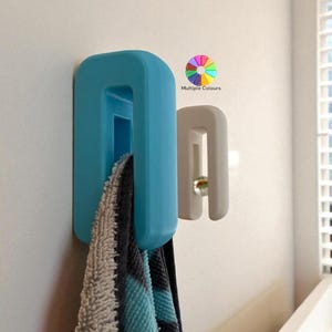 May include: Two wall-mounted towel holders in blue and white. A multi-coloured graphic with the text "Multiple Colours" is in the upper right corner. A towel hangs from the blue holder.