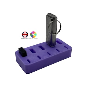 May include: A purple plastic organizer with multiple slots, holding a silver metal USB drive. A small black rectangular object is on the left side. The image includes the text "Made in the UK Multiple Colours".