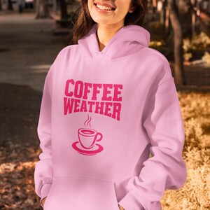 May include: Pink hoodie with the text "COFFEE WEATHER" in pink lettering and a pink coffee cup graphic.