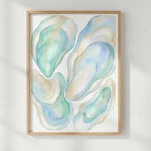 Peut inclure: Une impression encadrée à l'aquarelle représentant des formes abstraites dans des tons de bleu, de vert et de beige. L'œuvre est présentée dans un cadre en bois de couleur claire. L'impression est montée sur un fond blanc.
