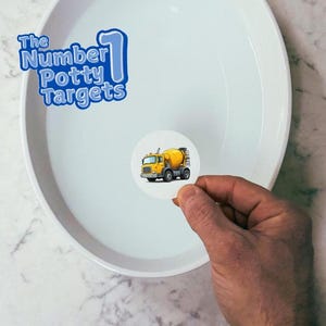 May include: A white round sticker with a cartoon image of a yellow cement mixer truck. The sticker is being held over a white ceramic bowl filled with water. The text "The Number 1 Potty Targets" is visible in the top left corner of the image.