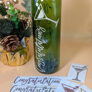 May include: A green glass bottle featuring a white martini glass design and the word "Congratulations" in a script font. Several martini glass decals and the word "Congratulations" are also visible.
