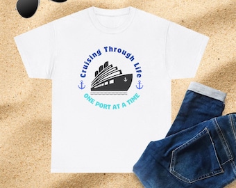May include: White t-shirt with a blue and teal graphic of a cruise ship and the text "Cruising Through Life One Port At A Time".