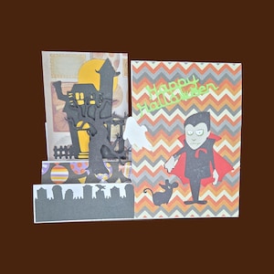 May include: A handmade Halloween card featuring a haunted house silhouette, a vampire, a ghost, and a mouse. The card has a colorful chevron pattern and the words "Happy Halloween".