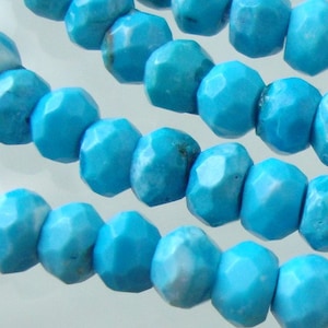 May include: A strand of turquoise beads, each bead is faceted and has a light blue color.