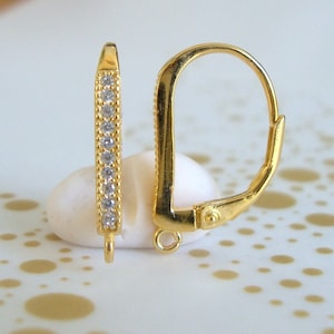 May include: Gold-tone earring with a lever back closure and a row of clear cubic zirconia stones.
