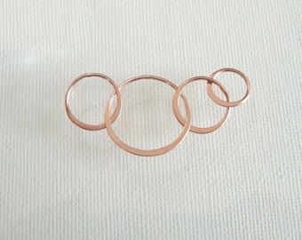 May include: A set of four interlocking circles made of rose gold metal.