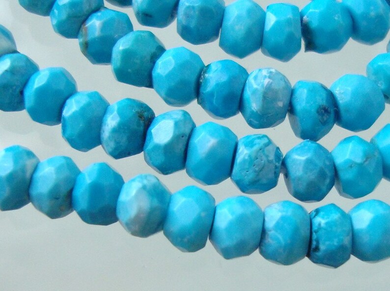 May include: A strand of turquoise beads, each bead is faceted and has a light blue color.