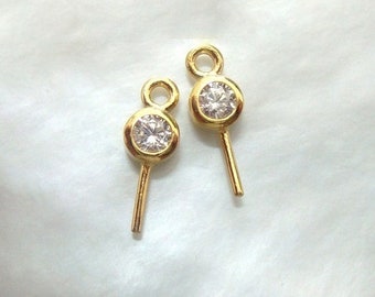May include: Two gold-tone earring findings with a clear round rhinestone in the center. Each finding has a loop at the top and a straight pin at the bottom.