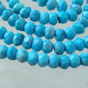 May include: A strand of turquoise beads, each bead is faceted and has a light blue color.