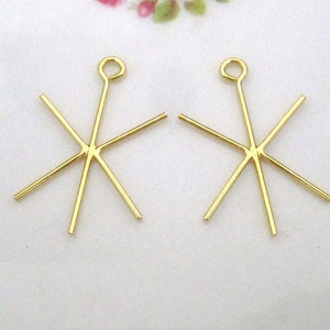 May include: Two gold-toned metal star-shaped pendant settings with six prongs each. The settings have a loop at the top for attaching to a chain or cord.