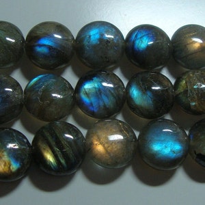 May include: A strand of round, iridescent labradorite gemstone beads. The beads are a dark gray color with blue and green flashes of color.