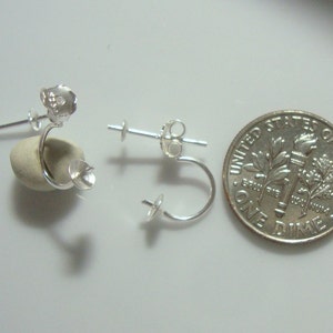 May include: Three silver earring findings with a loop and a post. The findings are shown next to a US dime for size comparison.