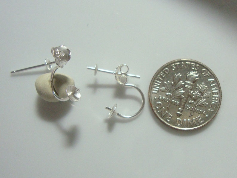 May include: Three silver earring findings with a loop and a post. The findings are shown next to a US dime for size comparison.