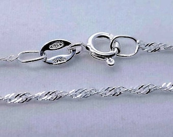 May include: A silver chain necklace with a lobster clasp closure. The chain is a twisted rope design and is marked "925" on the clasp.