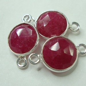 May include: Three round, faceted ruby gemstone connector charms with silver-toned metal settings and jump rings.