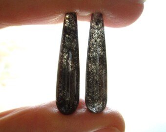 Peut inclure: Paire de boucles d'oreilles en quartz clair en forme de goutte avec des inclusions noires. Les boucles d'oreilles mesurent environ 2,5 cm de long.