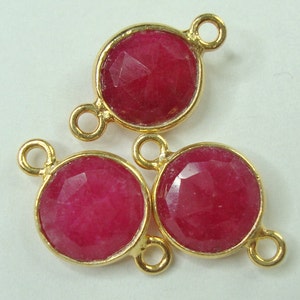 Può includere: Tre ciondoli connettore dorati con accenti di pietre preziose rosa. Ogni ciondolo ha due anelli per il fissaggio ai gioielli.