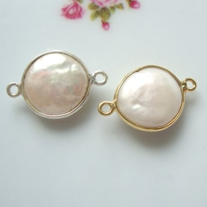 May include: Two round pearl connectors, one with a silver finish and one with a gold finish. Both connectors have two loops for attaching jewelry.