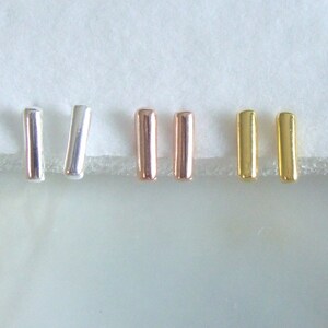 May include: Six small bar-shaped earrings in silver, rose gold, and gold.