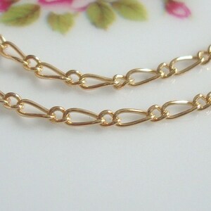 May include: Two strands of gold chain with a delicate, oval-shaped link design.