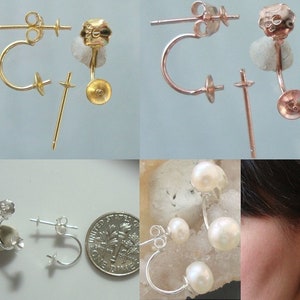 May include: Three pairs of earring findings in gold, rose gold, and silver. Each pair includes a post and a curved hook. The findings are designed to be used with pearls or other gemstones.