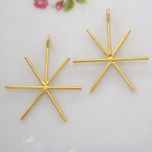 Peut inclure: Deux montures de pendentif en forme d'étoile en métal doré avec six griffes chacune.