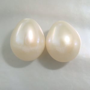 May include: Two pearlescent white oval-shaped beads.