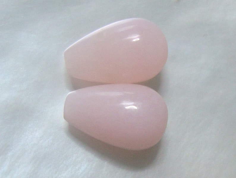 May include: Two teardrop-shaped pink opal beads.