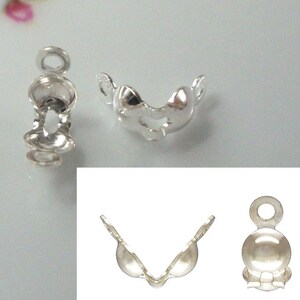 May include: Silver-toned metal clasps for jewellery making. The clasps are designed to hold a strand of beads or other jewellery components. The clasps are shown in three different positions.