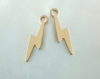 May include: Two gold-colored metal lightning bolt charms with a jump ring at the top.