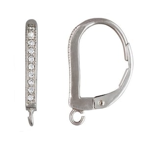 May include: A pair of silver-toned hoop earrings. One earring features a row of small, clear gemstones along the front. The other earring has a hinged clasp. The earrings are displayed against a white background.