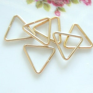 May include: Six gold triangle jump rings. These rings are ideal for jewellery making, crafting, and DIY projects.