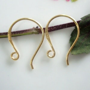 May include: Two gold-toned earring hooks with a small loop at the top and a curved hook at the bottom. The hooks are marked with the number "925".