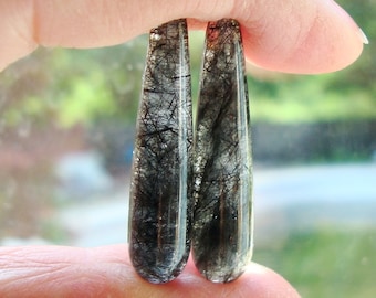 Peut inclure: Deux cabochons de quartz noir et clair en forme de larme avec des inclusions de tourmaline noire.