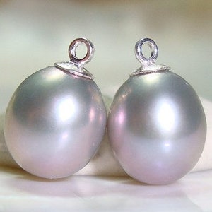 May include: Two silver-toned pearl pendants with a loop at the top for attaching to jewelry. The pearls are a light gray color with a slight iridescent sheen.