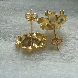 K&ouml;nnte beinhalten: Ein Paar goldfarbene Ohrringe mit einem floralen Design. Die Ohrringe sind aus Metall und haben einen Stiftverschluss.