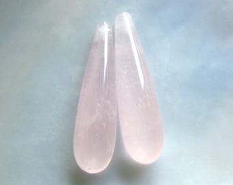 May include: Two pale pink teardrop-shaped crystal points.