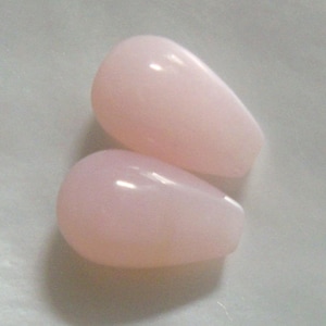 May include: Two teardrop-shaped pink opal stones.