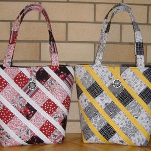 May include: Two quilted tote bags with diagonal stripes. One bag is red, white and black, and the other is yellow, white and black.
