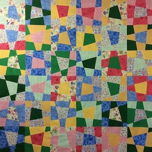 May include: A patchwork quilt with a geometric pattern of squares and rectangles in various colors, including pink, blue, green, yellow, and red.