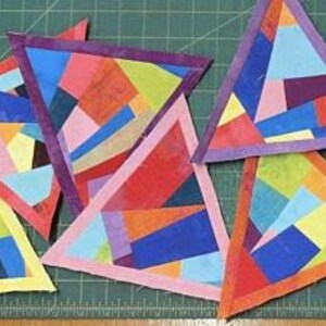 Peut inclure: Une collection de pièces de tissu triangulaires présentant une mosaïque de formes géométriques multicolores dans des tons de bleu, rouge, jaune, rose et violet. Chaque triangle est bordé par un biais en tissu uni de couleurs vives.