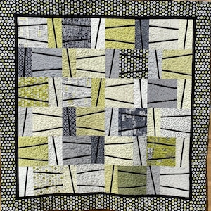 Może przedstawiać: Kołdra z geometrycznym wzorem w kolorze czarnym, białym i zielonym. Kołdra składa się z kwadratów i prostokątów, a wzór powstaje poprzez zastosowanie różnych tkanin i kolorów. Kołdra jest obszyta czarno-białą tkaniną w kropki.