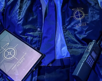 May include: A dark blue windbreaker jacket with a gold S.C.H.A.L.E. logo, worn over a white collared shirt and a dark blue tie. A tablet displays the same gold logo, and a black handheld radio sits nearby, completing this coordinated ensemble.