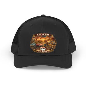 May include: Black trucker hat featuring a Route 66 Centennial design. The graphic depicts classic cars on a desert road at sunset, with the text "100 Years" and "Route 66 Centennial" displayed in a circular emblem.