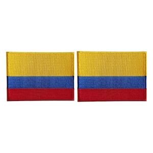 May include: Two rectangular embroidered patches featuring the horizontal tricolor flag of Colombia. Each patch displays a wide yellow band on top, a blue band in the middle, and a red band on the bottom, all with a textured stitched finish.