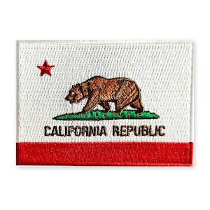 May include: A rectangular embroidered patch featuring the California state flag design. It displays a brown grizzly bear standing on a green patch of grass, a red star in the upper left, and the text CALIFORNIA REPUBLIC in black letters.