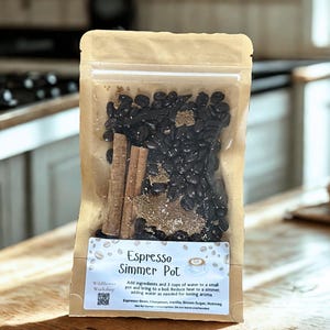 May include: A clear, resealable bag filled with espresso beans, cinnamon sticks, and spices. The label reads "Espresso Simmer Pot" with instructions and ingredient list. The bag is on a wooden surface.