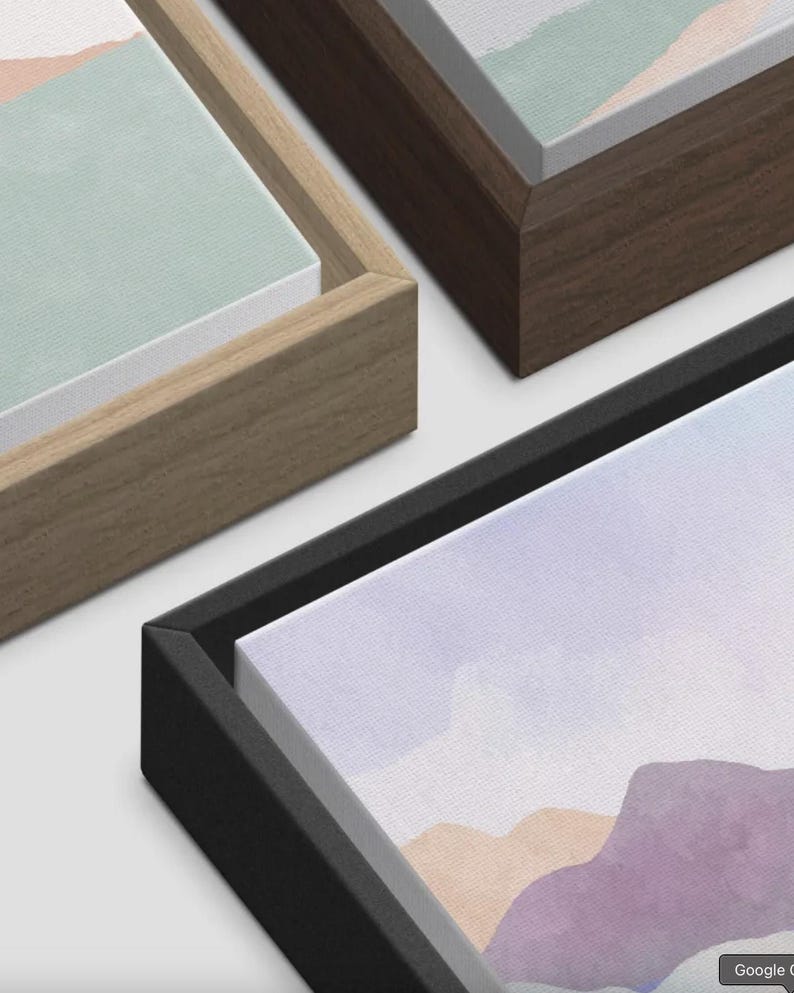 May include: Close-up of framed canvas art pieces. The artwork features watercolor landscape paintings in pastel colors. The frames are in various colors, including natural wood, dark brown, and black.